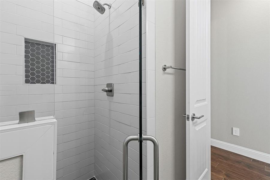 Bathroom featuring a shower stall and dark wood-style floors Bathroom featuring a shower stall and dark wood-style floors