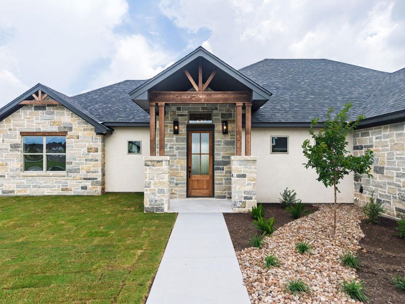 A striking exterior featuring a blend of natural stone and stucco, with a welcoming covered entry. A striking exterior featuring a blend of natural stone and stucco, with a welcoming covered entry.