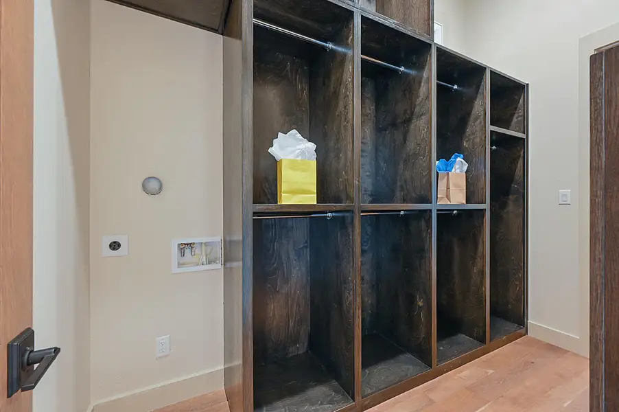 His closet with built ins and room for  stackable washer and dryer