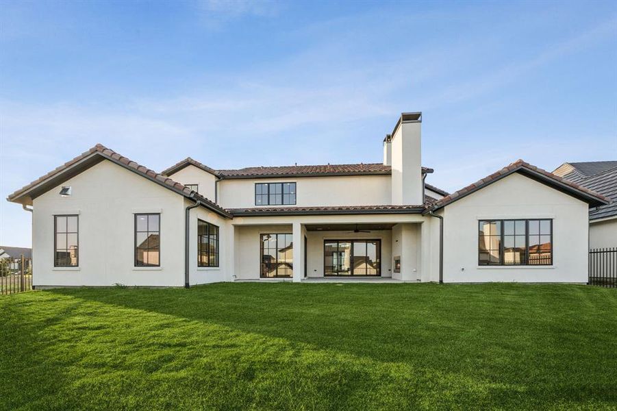 Back of property with a ceiling fan, a chimney, stucco siding, and a patio Back of property with a ceiling fan, a chimney, stucco siding, and a patio