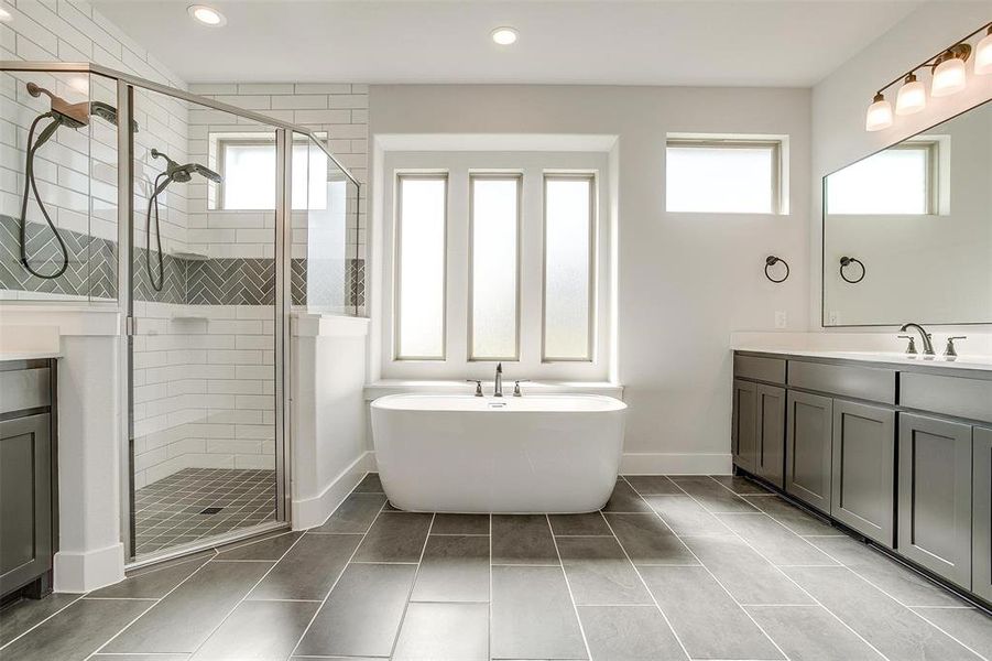 Bathroom featuring vanity, a healthy amount of sunlight, tile patterned floors, and separate shower and tub