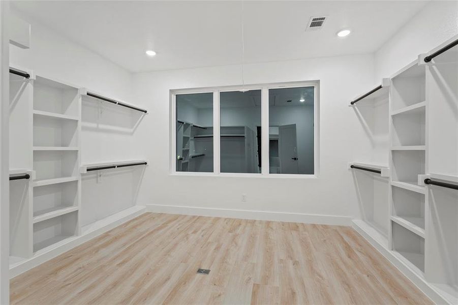 Spacious closet featuring light wood-style floors Spacious closet featuring light wood-style floors