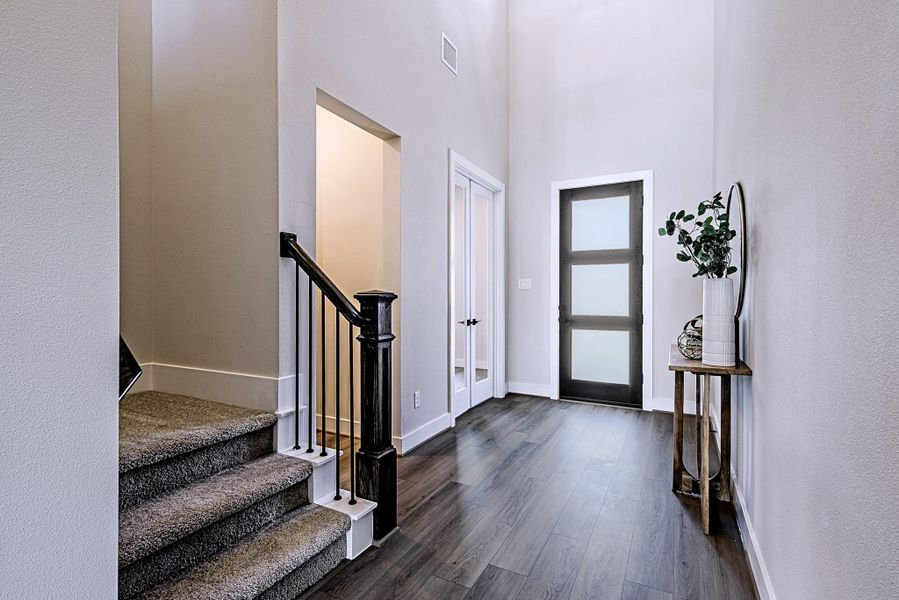 Welcoming foyer with a modern front door and staircase leading to the second floor