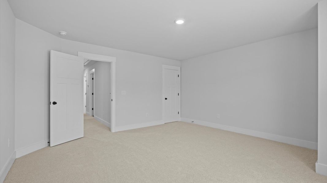 Superior comfort in a secondary bedroom with plush carpet and an oversized walk-in closet