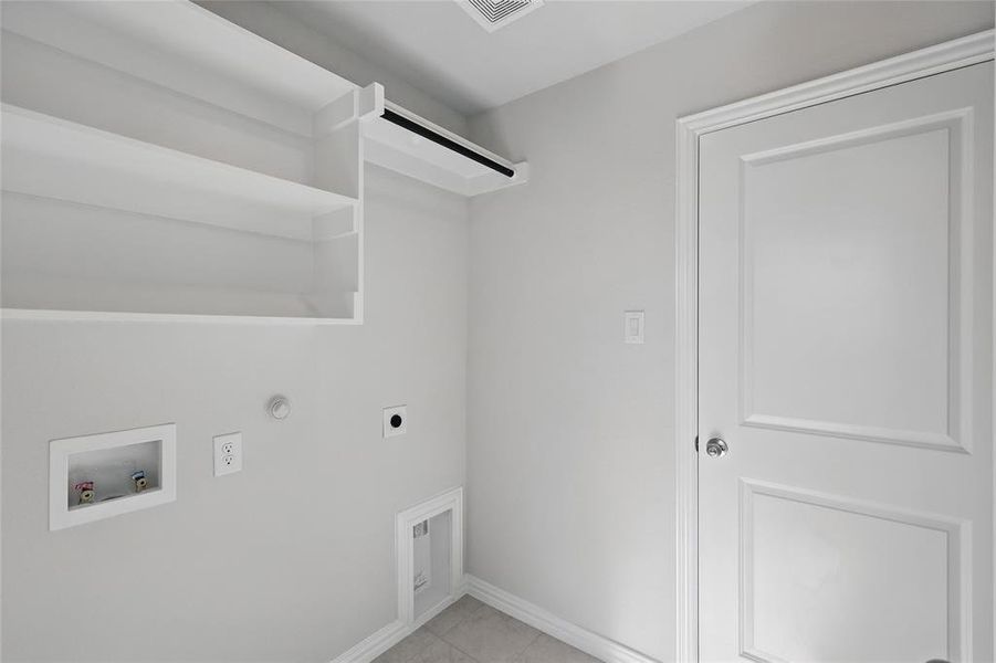 Laundry room with gas dryer hookup, washer hookup, electric dryer hookup, and light tile patterned floors Laundry room with gas dryer hookup, washer hookup, electric dryer hookup, and light tile patterned floors