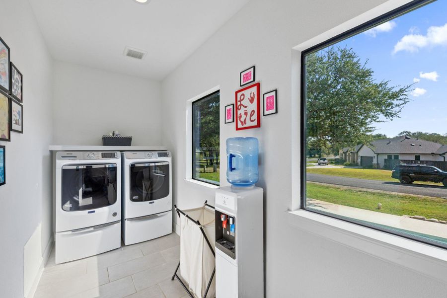 Washroom with light tile patterned flooring and separate washer and dryer