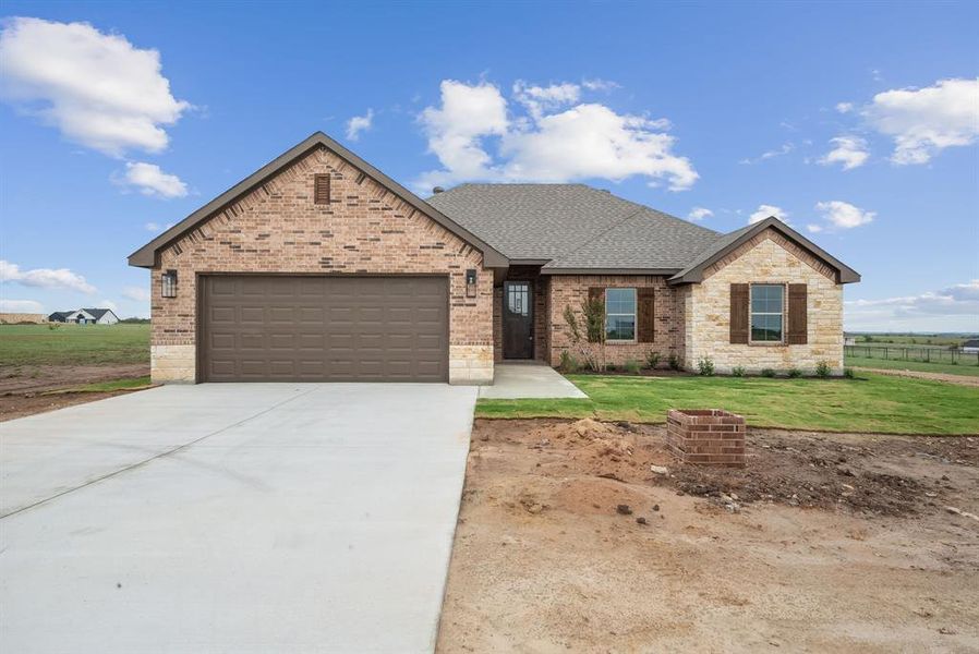 Craftsman inspired home with a garage and a front lawn