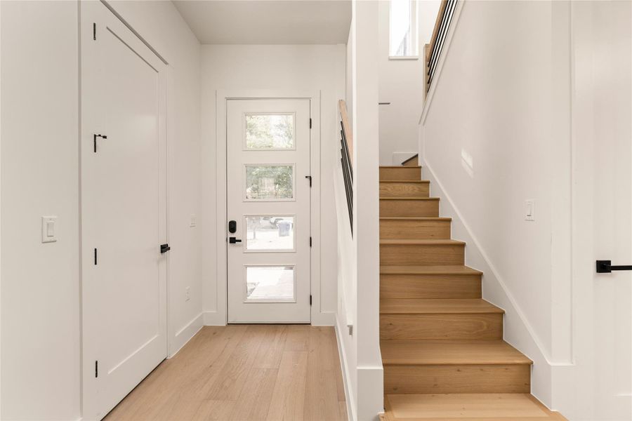 Entrance foyer featuring stairway and light wood-style floors