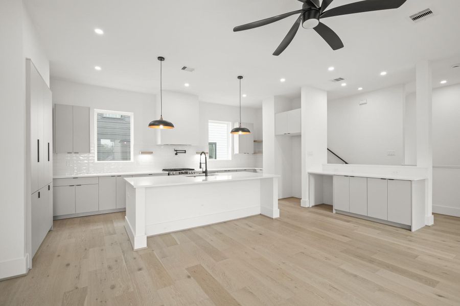Imagine mornings in this beautiful kitchen, where natural light sets the tone for the day. The center island with pendant lights offer the perfect gathering spot, while the stainless steel sink with black faucet,  quartz counters, subway tile back splash and pot filler makes cooking effortless.