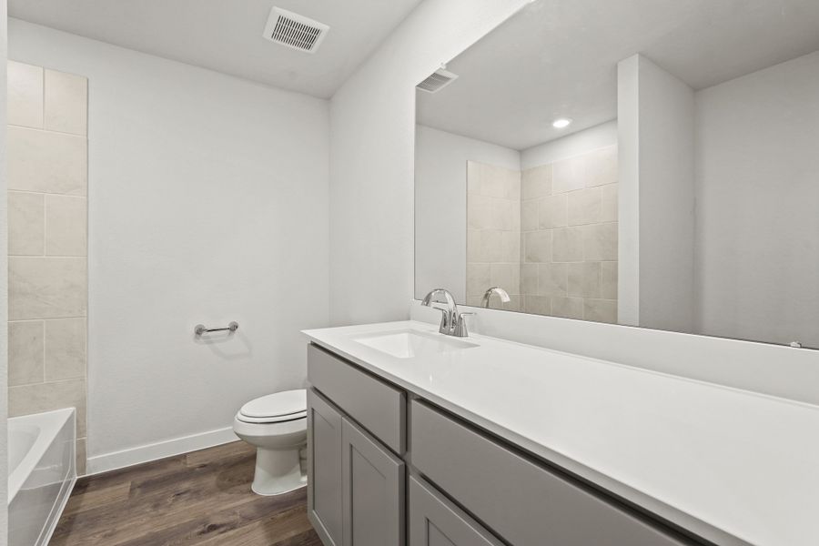 A bathroom with a tub toilet and sink.