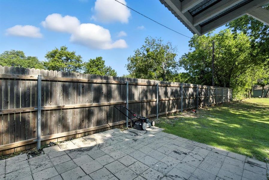 Fenced backyard with a patio area Fenced backyard with a patio area