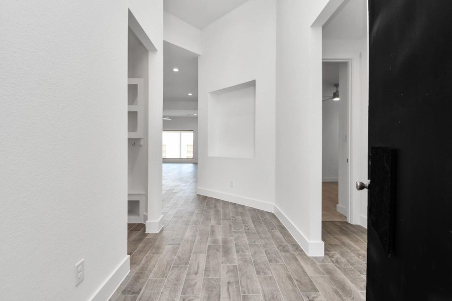 As you step into the threshold of this luxurious home, you'll soon be welcomed by an elegant glass door (to be installed). Inside, soaring ceilings amplify the spaciousness, while the refined wood-look tile flooring and oversized baseboards exude sophistication and charm.