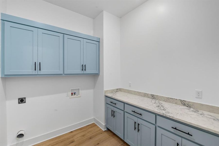 Laundry room featuring cabinet space, light wood-style flooring, hookup for a washing machine, and hookup for an electric dryer Laundry room featuring cabinet space, light wood-style flooring, hookup for a washing machine, and hookup for an electric dryer