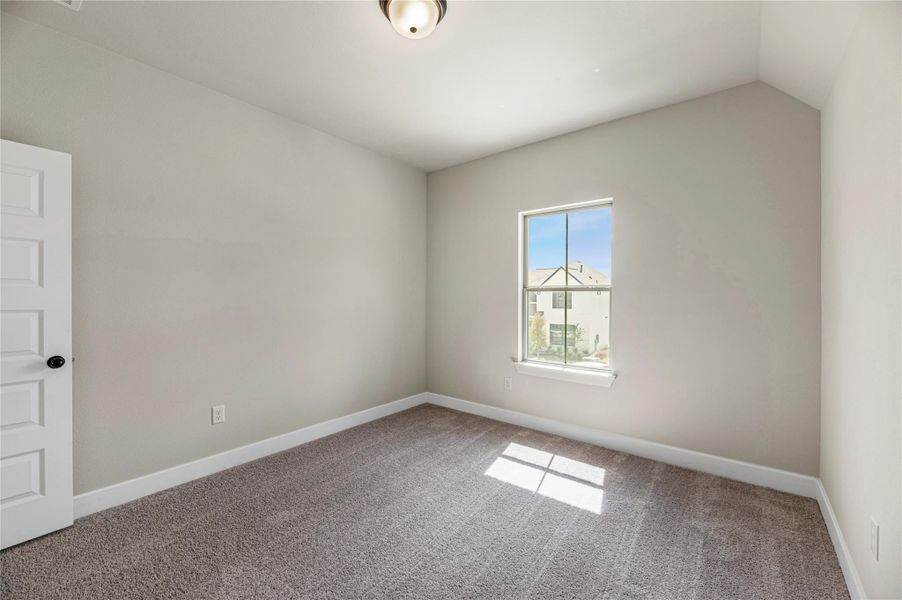 Spare room featuring carpet flooring and baseboards