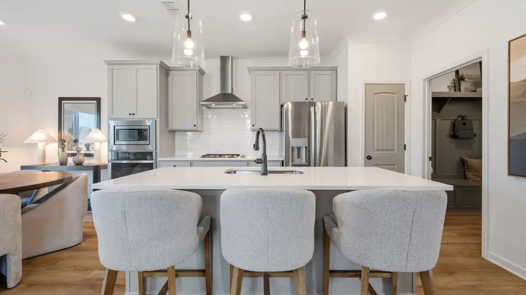 Spacious kitchen with center island and stylish cabinetry in Langley Overlook new construction townhome in Loganville, GA.