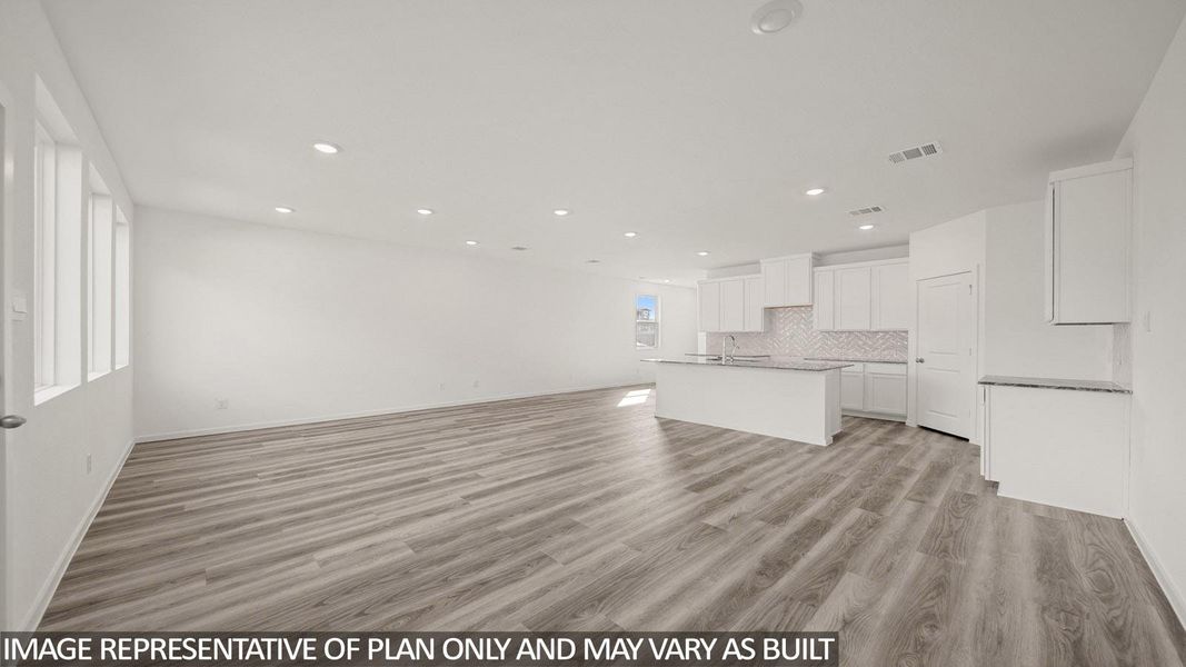 Spacious room featuring wood-finish flooring, recessed lighting, and multiple windows