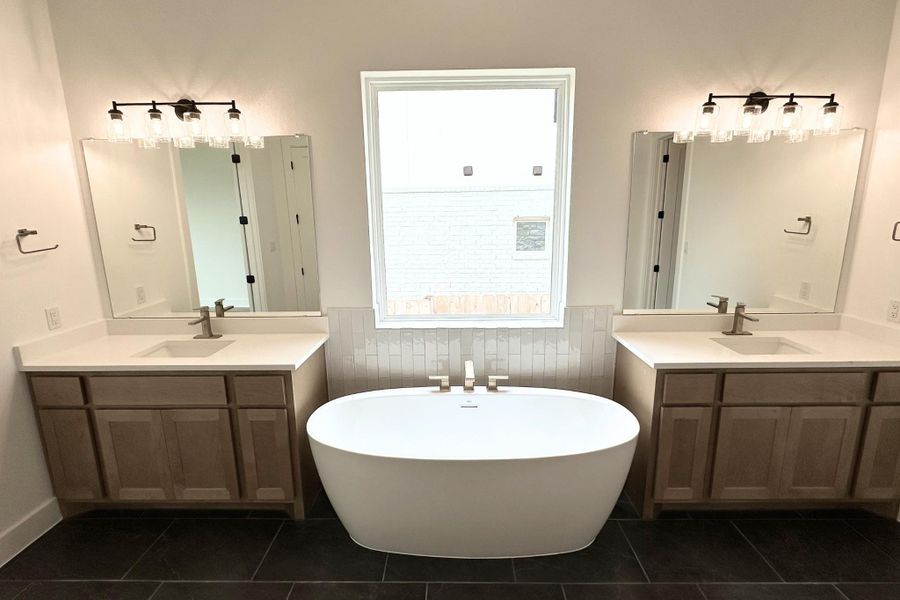 Indulge in a tranquil retreat featuring a spacious soaking tub and dual vanities, perfect for daily rejuvenation.