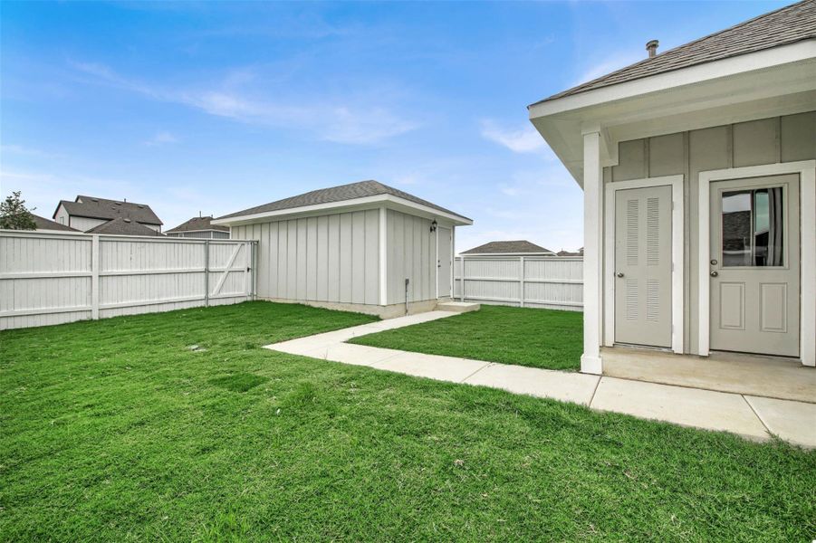 Fenced backyard with an outdoor structure