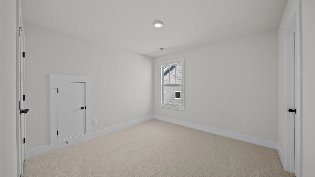 Highly functional bedroom with large windows, carpeted flooring, and tasteful finishes throughout Highly functional bedroom with large windows, carpeted flooring, and tasteful finishes throughout