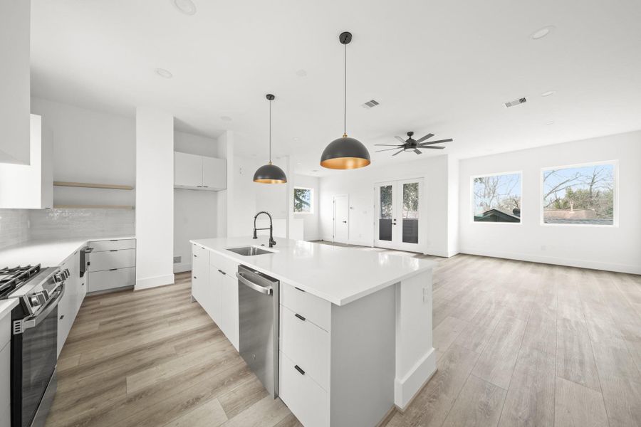 The island serves as the kitchen's functional centerpiece, housing the stainless steel undermount sink and a GE stainless steel dishwasher for a clean, efficient workspace. The island serves as the kitchen's functional centerpiece, housing the stainless steel undermount sink and a GE stainless steel dishwasher for a clean, efficient workspace.