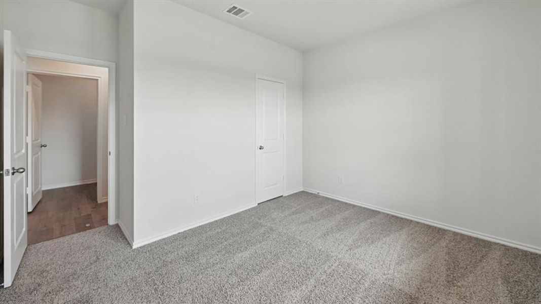 Unfurnished bedroom with carpet flooring and baseboards