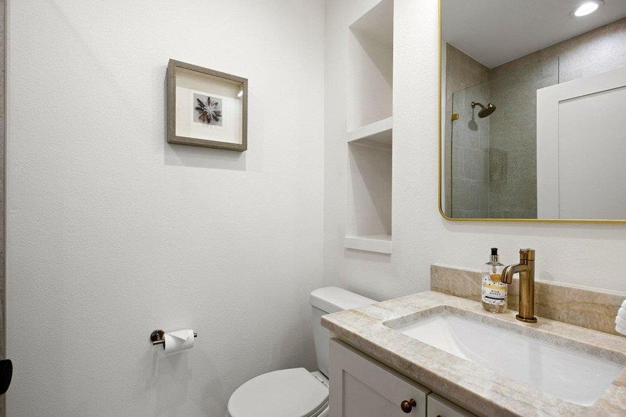 A well-appointed bathroom with a sleek vanity, elegant bronze fixtures, and a shower with glass enclosure. A well-appointed bathroom with a sleek vanity, elegant bronze fixtures, and a shower with glass enclosure.