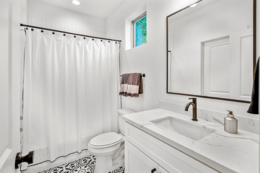 This en-suite guest bathroom is thoughtfully appointed with modern fixtures.