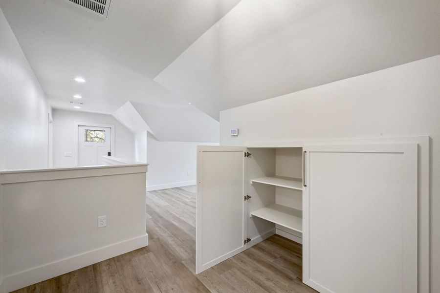 Custom cabinetry with inset shelving maximizes use of space beneath the sloped ceiling. Custom cabinetry with inset shelving maximizes use of space beneath the sloped ceiling.