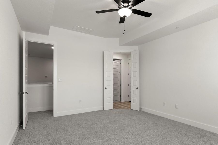Unfurnished bedroom with light carpet and a ceiling fan
