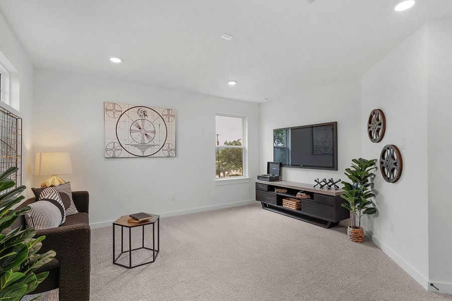 Living area with light colored carpet, baseboards, healthy amount of natural light, and recessed lighting
