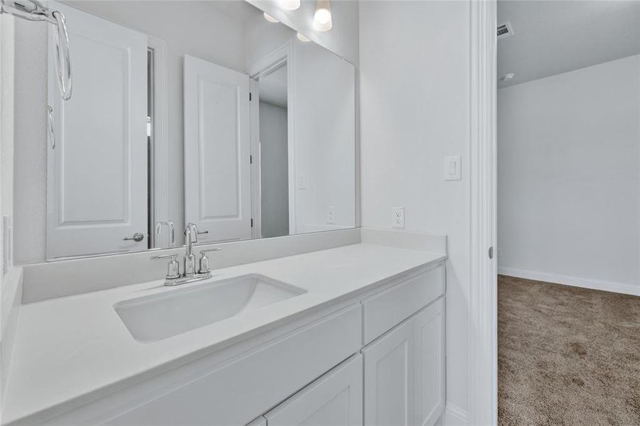 Bathroom with vanity and light carpet