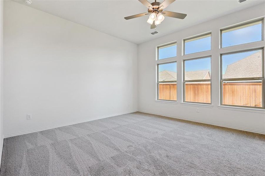 Spare room with ceiling fan and light colored carpet