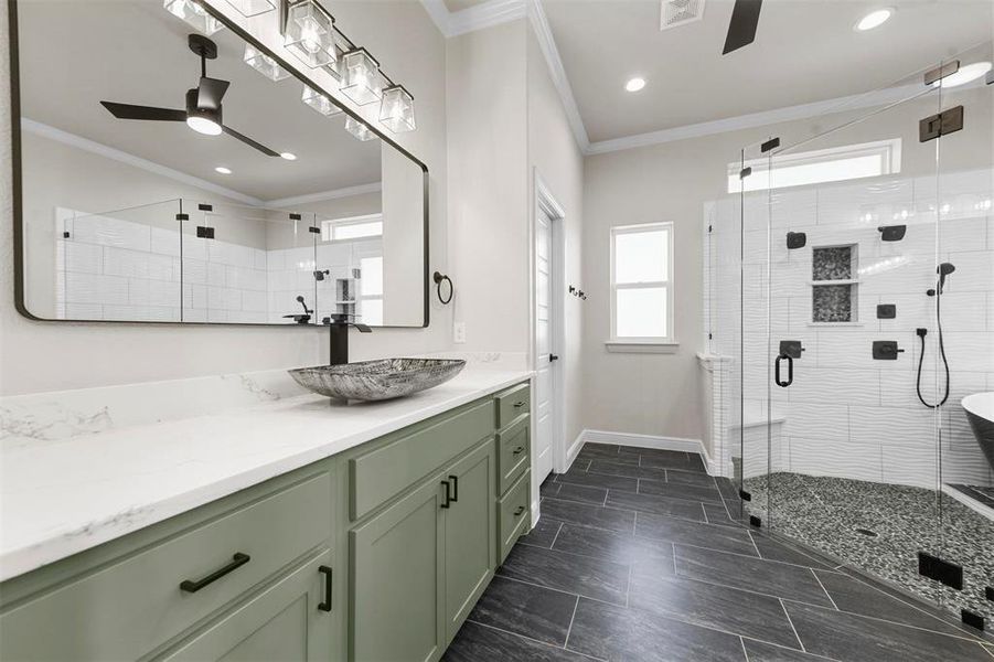 Bathroom featuring ceiling fan, vanity, a shower with shower door, and ornamental molding