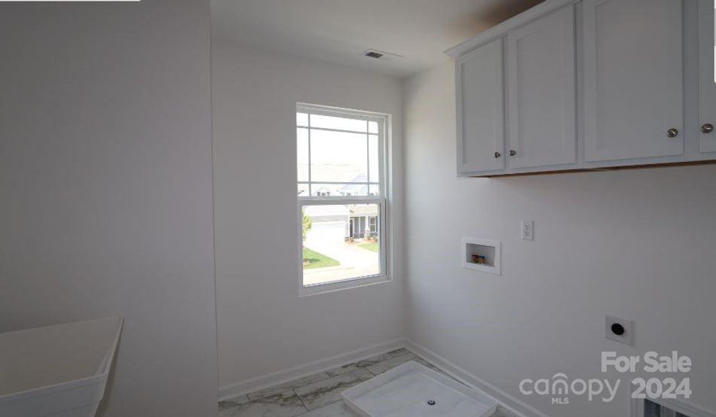 Laundry Room with wall mounted laundry tub and wall cabinets