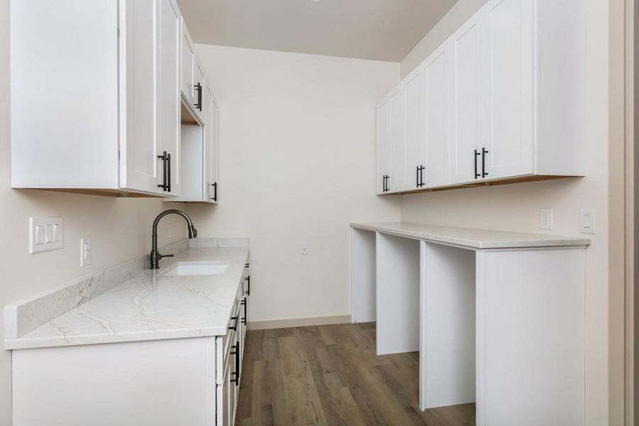 Kitchen with white cabinets, light stone countertops, and light wood-style floors Kitchen with white cabinets, light stone countertops, and light wood-style floors
