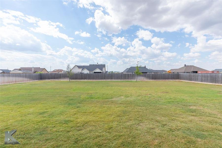 Fenced backyard with a residential view Fenced backyard with a residential view