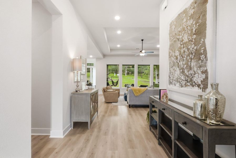Step through the front door into a beautiful, light-filled foyer that immediately sets a peaceful tone, offering views straight through to the wooded backyard