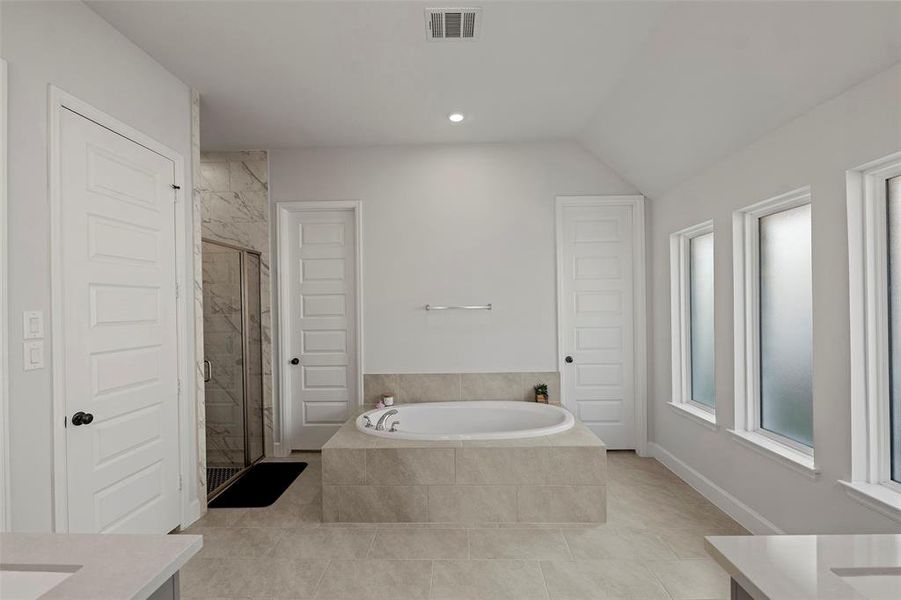 Primary bath has a soaking tub with 2 closets