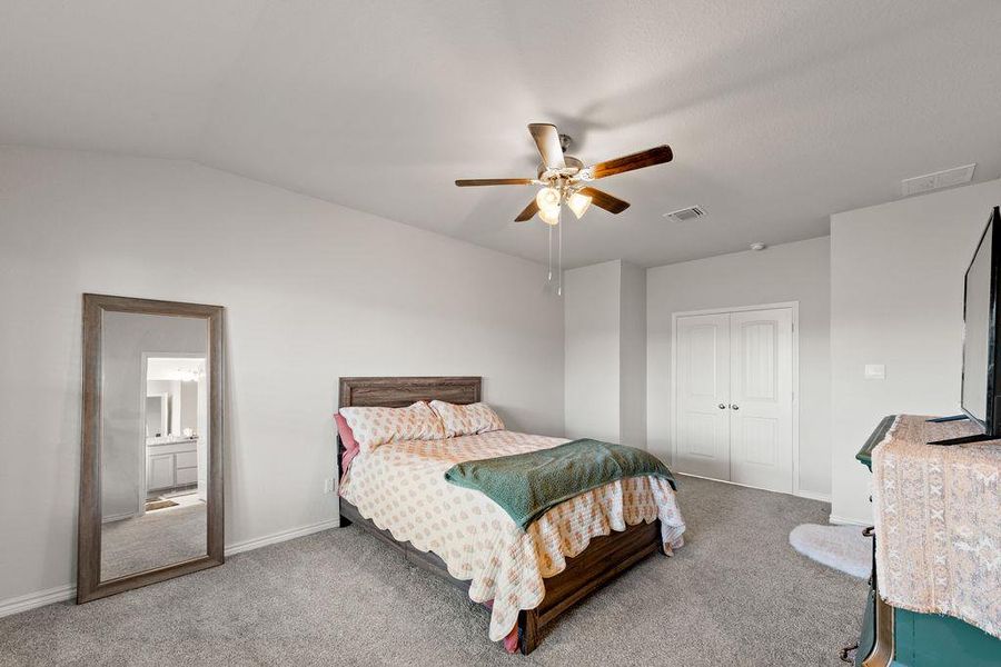 Bedroom featuring light carpet, a closet, a ceiling fan, and vaulted ceiling