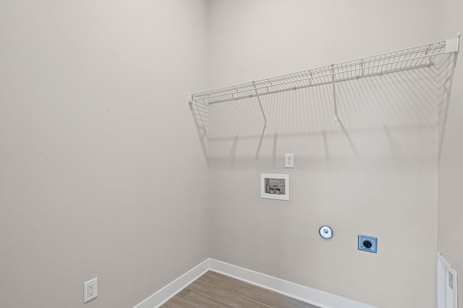 Laundry area with light wood finished floors, hookup for an electric dryer, and hookup for a washing machine