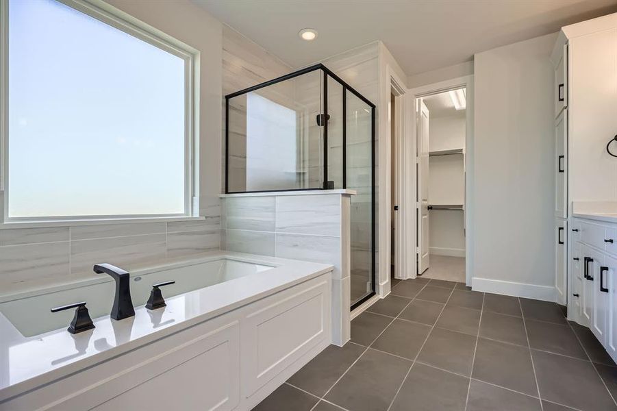 Bathroom with a shower stall, a garden tub, tile patterned floors, a walk in closet, and vanity Bathroom with a shower stall, a garden tub, tile patterned floors, a walk in closet, and vanity
