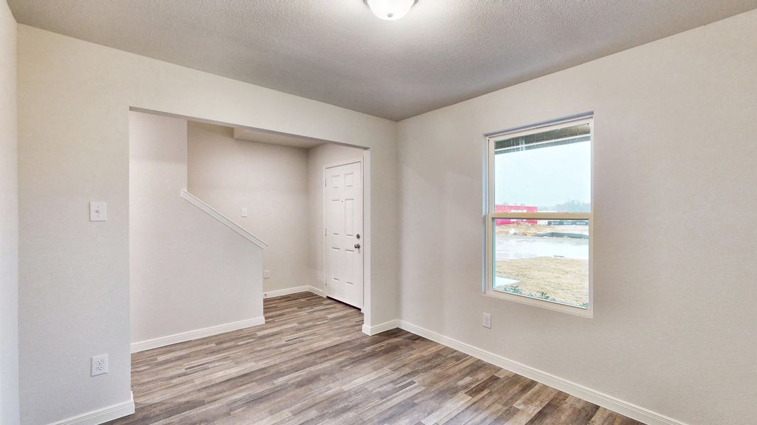 A room with a window and a wood floor.