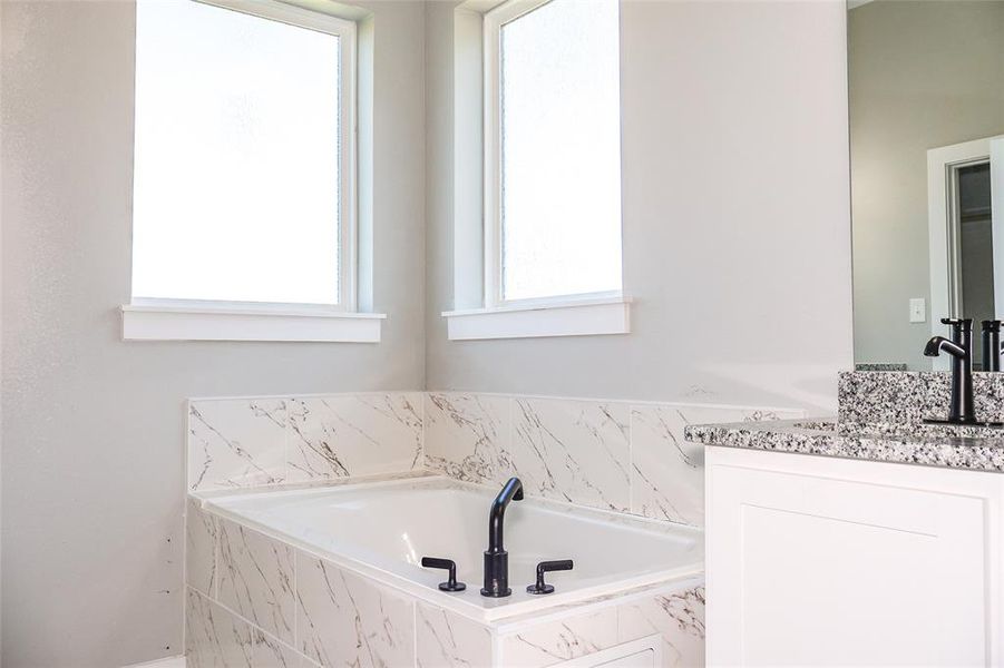 Bathroom featuring vanity and a bath