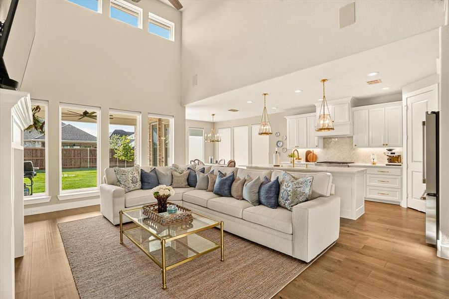 Two-story living area with wood-finish flooring and a high ceiling Two-story living area with wood-finish flooring and a high ceiling