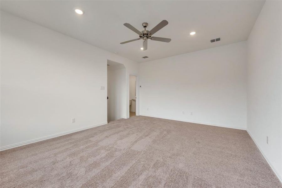 Carpeted empty room featuring ceiling fan