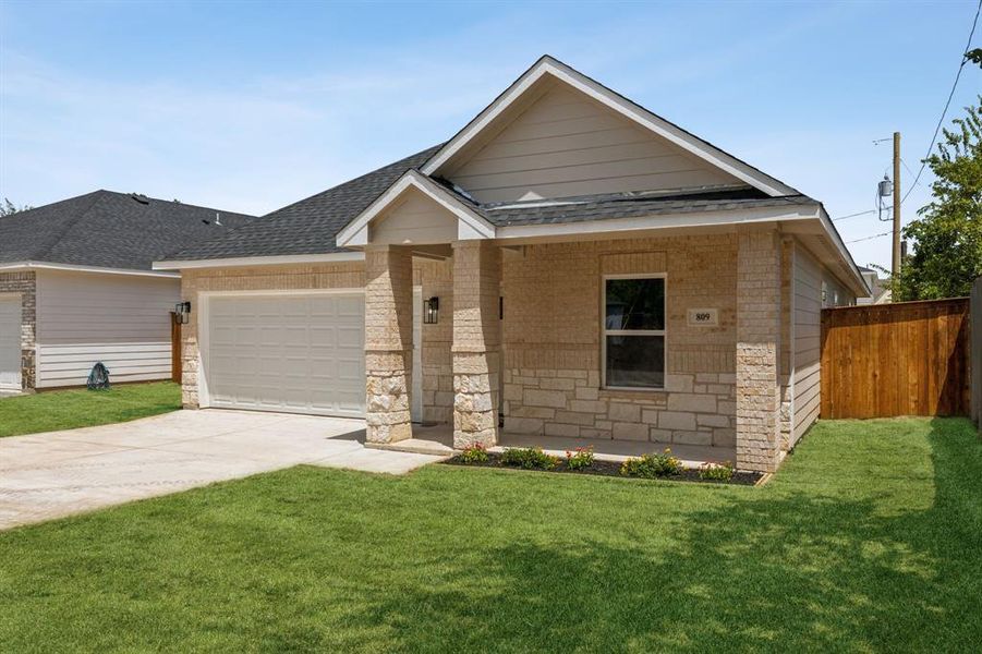 View of front of property featuring a garage and a front yard