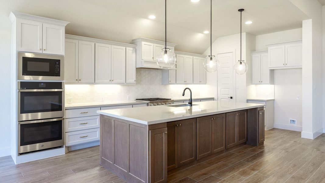 Kitchen featuring white cabinets, tasteful backsplash, wood tiled floors, recessed lighting, and vaulted ceiling