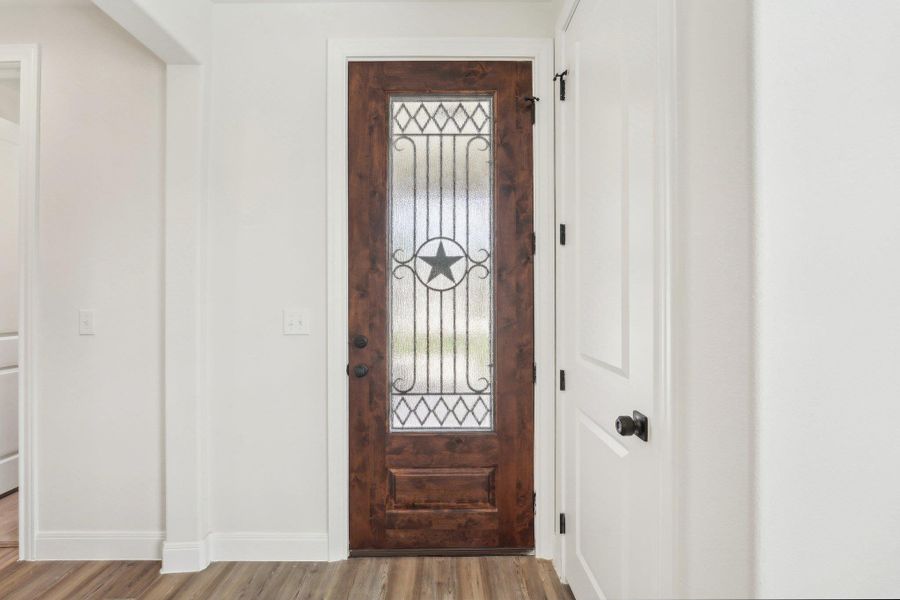 Foyer featuring light wood-style vinyl flooring and baseboards Foyer featuring light wood-style vinyl flooring and baseboards