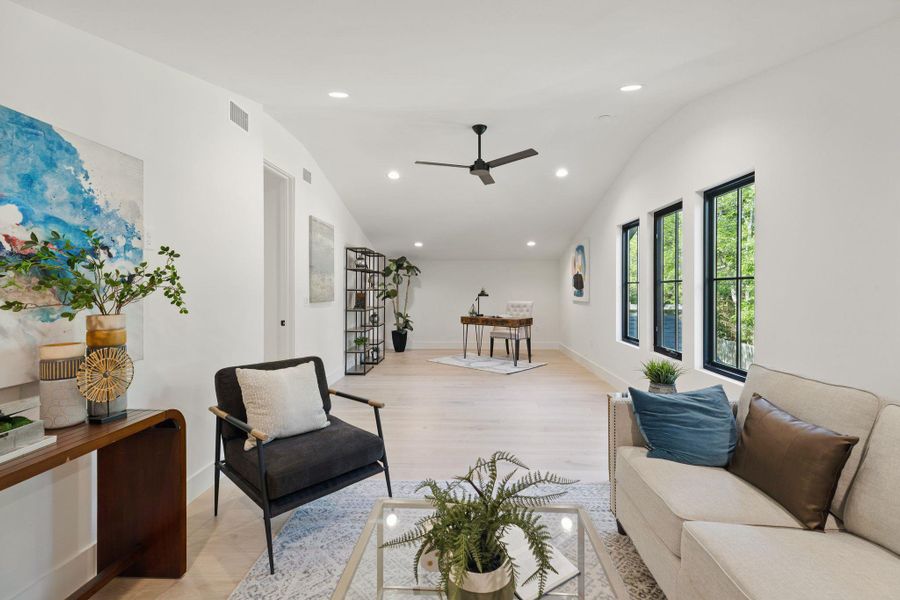 Living room featuring vaulted ceiling, a ceiling fan, recessed lighting, and light wood-style flooring