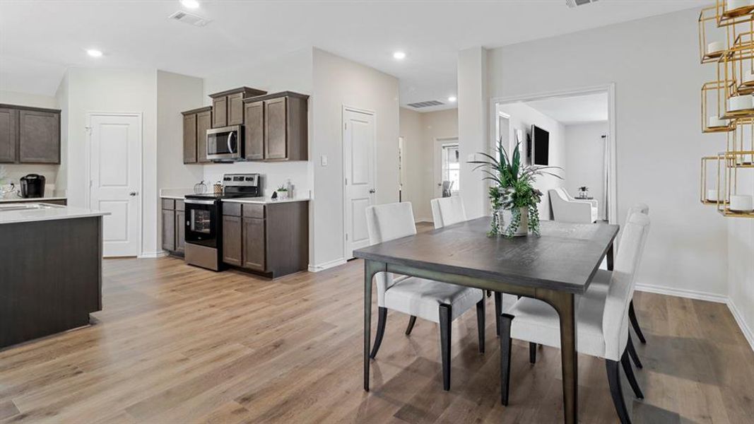 Dining area with light wood-style floors and recessed lighting